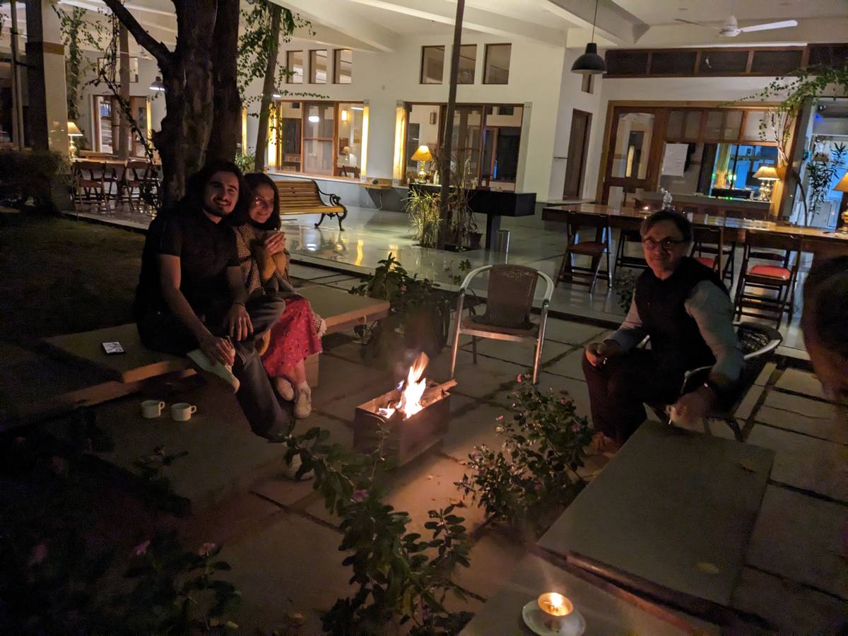 A group gathered quietly around the fire pit after dark