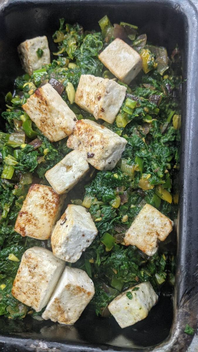 Paneer with greens in a black pan
