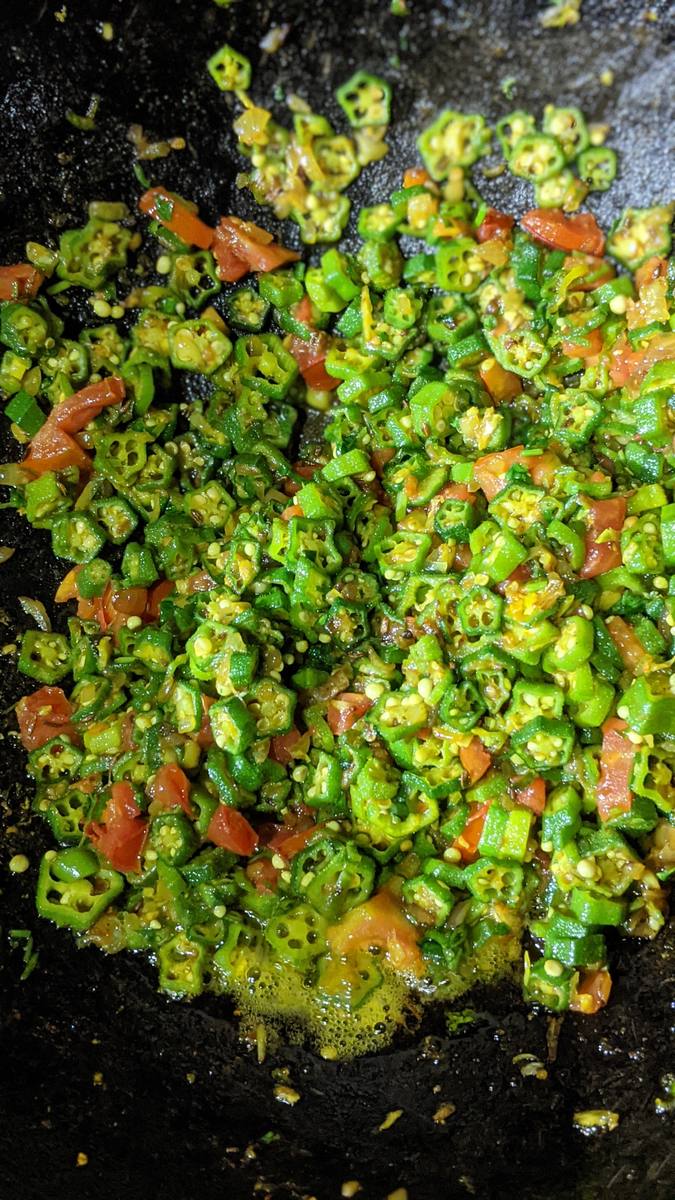 Okra and tomato cooking in the pan