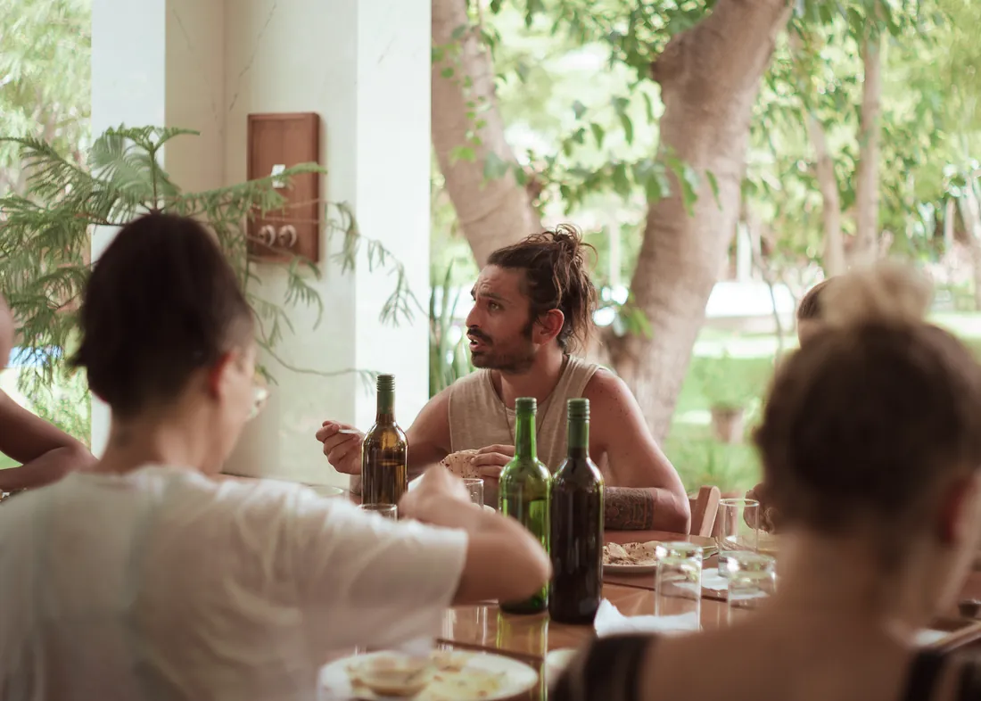 Guests sharing a meal beneath a tree at the farm