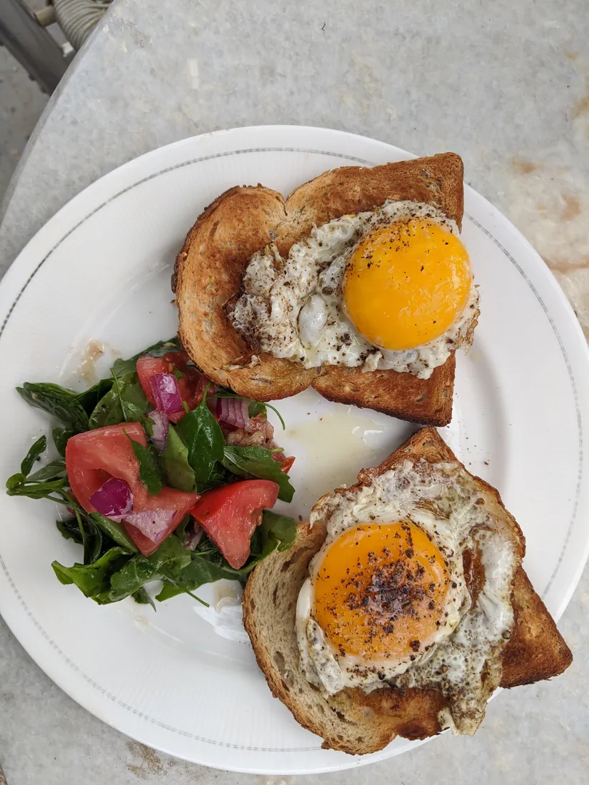 Fried eggs on toast with a fresh garden salad
