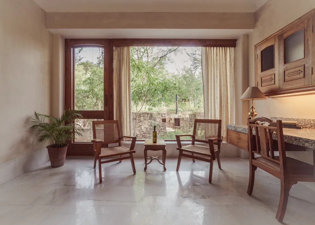 Suite work area with cane chairs, desk, and a garden window