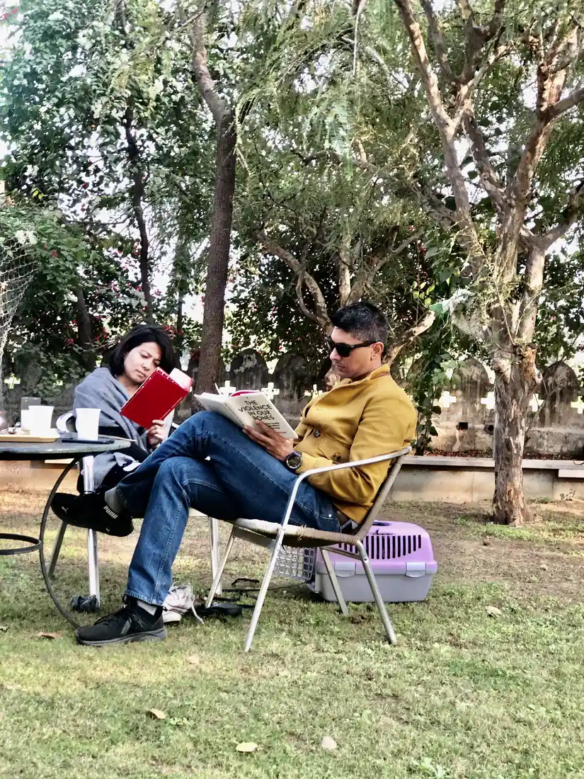 Two guests reading in the garden on a quiet morning — PushkarOrganic