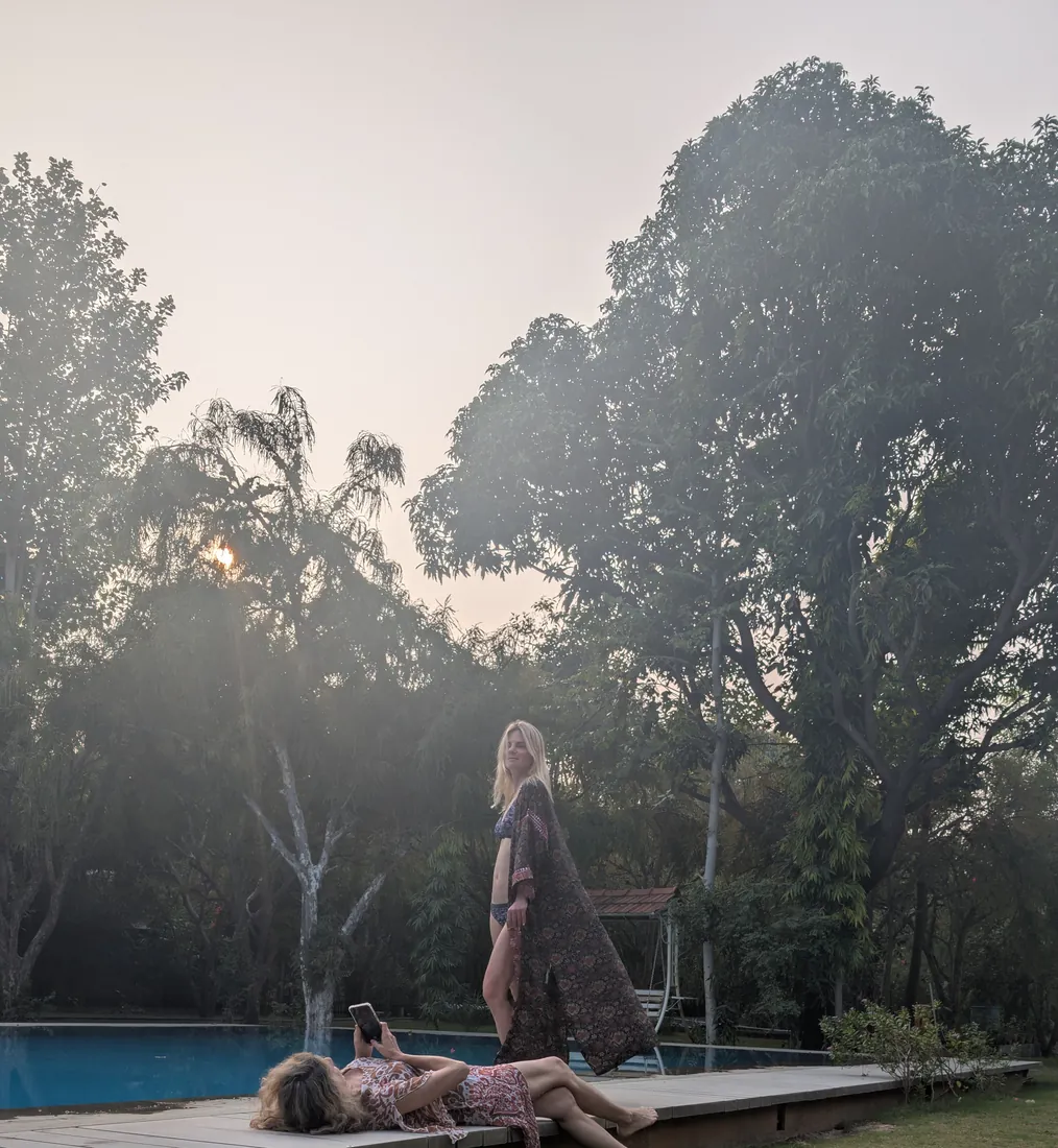 Guests at the pool in the hazy golden-hour light