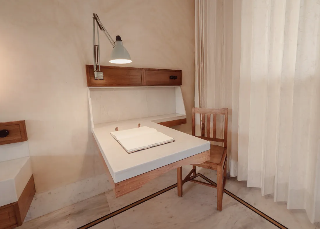 Deluxe room writing desk beside full-length curtains
