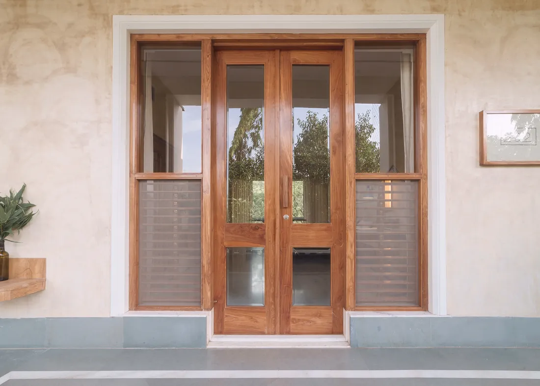 Teak double doors and glass side panels at the Deluxe room entrance