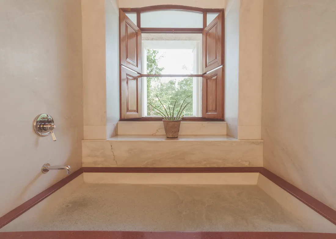 The Deluxe bathroom — marble tub beside the window