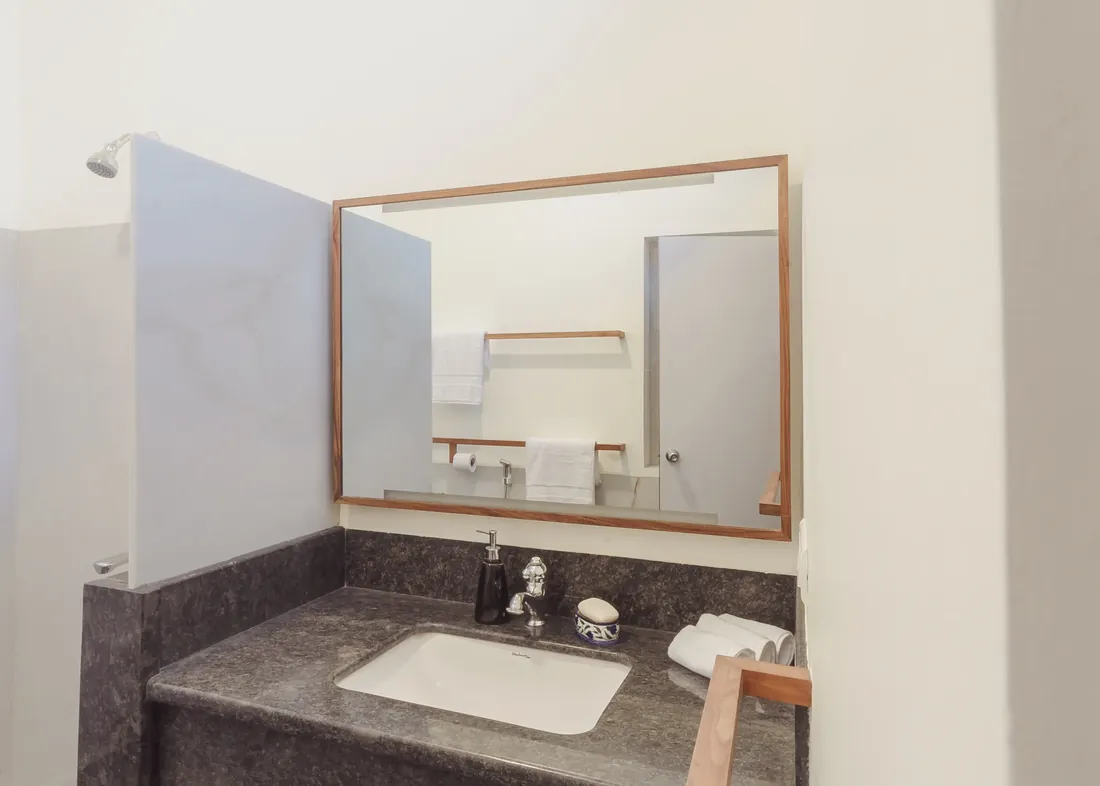 The Standard bathroom sink, mirror, shower, and folded towels
