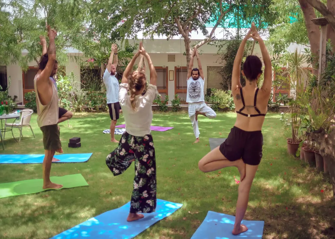 Guests practising yoga in the garden outside the Standard rooms