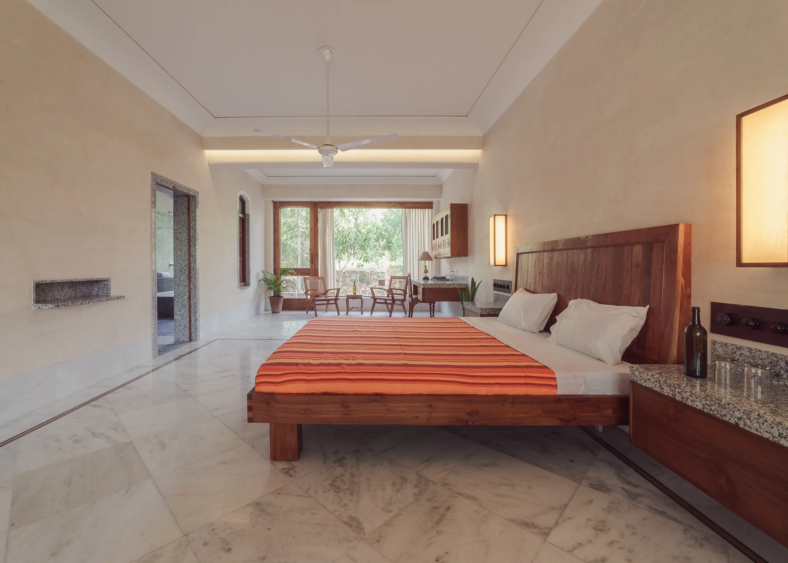 The Suite — bed, marble floor, work area, and garden window