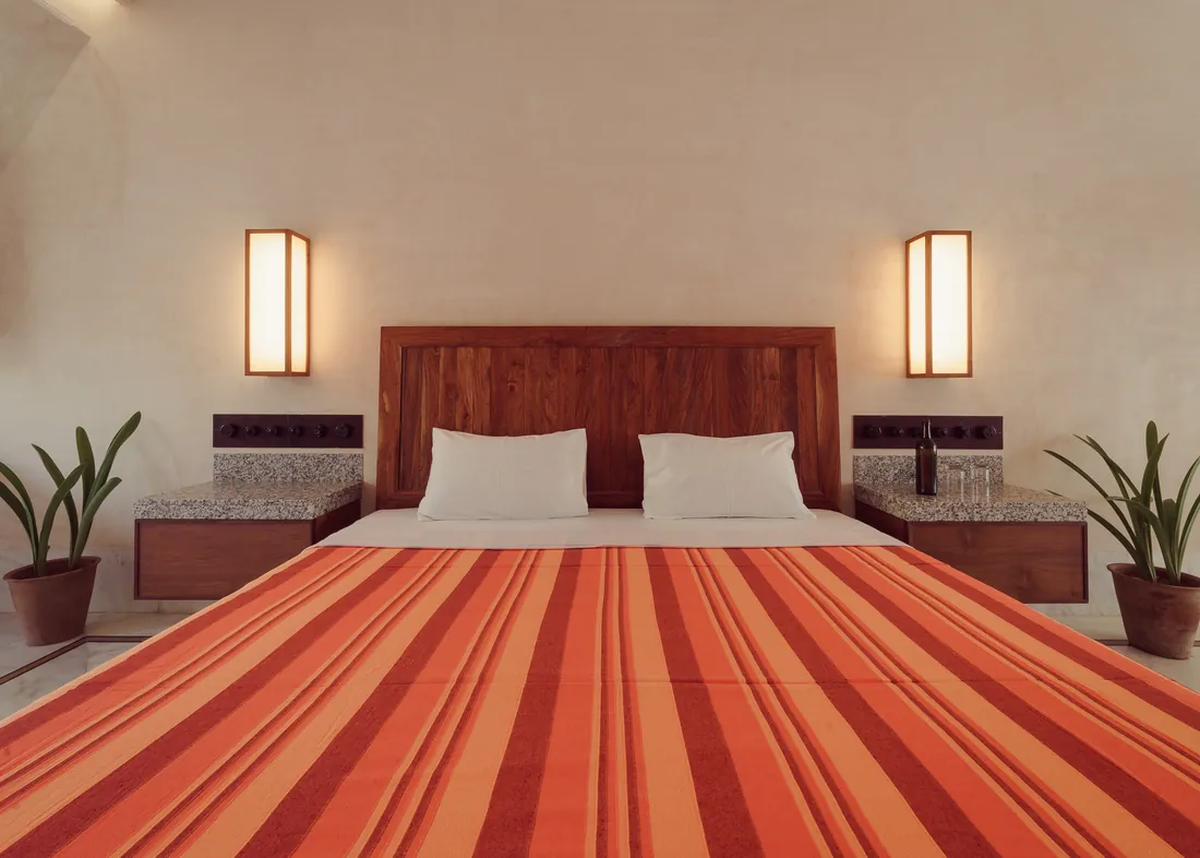 The Suite bed, teak headboard, marble nightstands