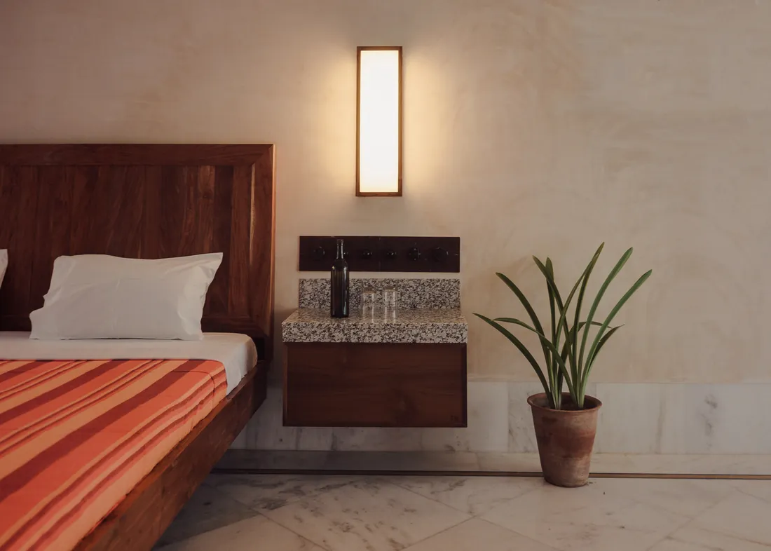 Bedside light, marble shelf, and plant in the Suite