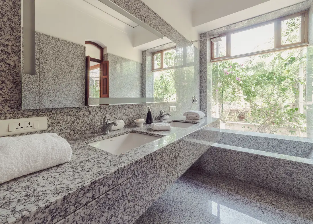 The two-person granite tub set beside the garden window