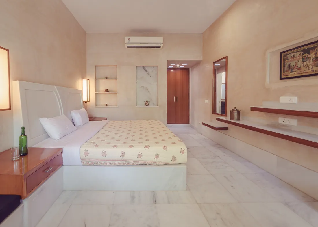 Standard room with bed, built-in shelves, wardrobe, and marble floor