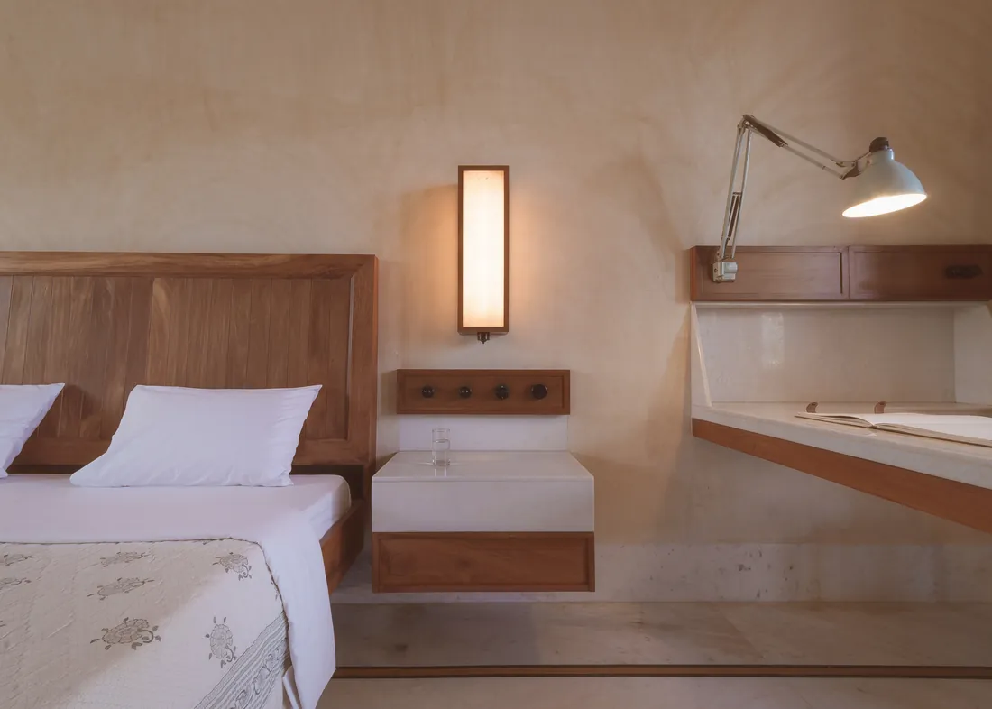 Standard room headboard, bedside lamp, and built-in writing desk