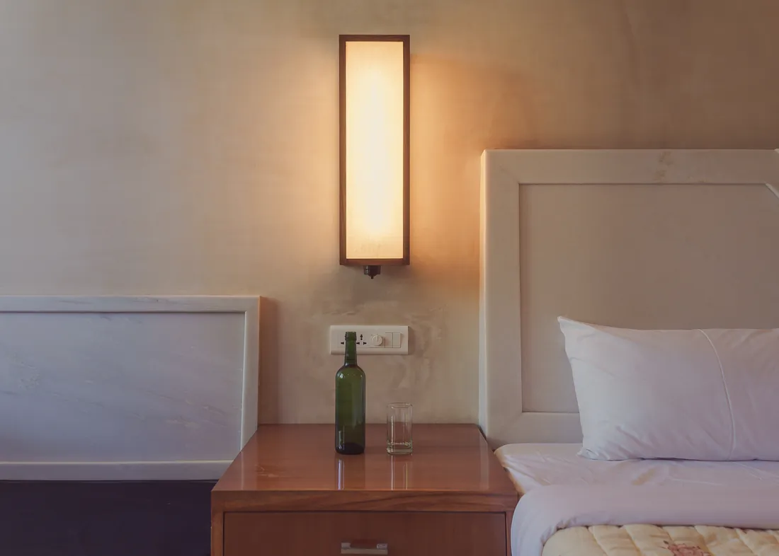 Bedside table — lamp, bottle, surface