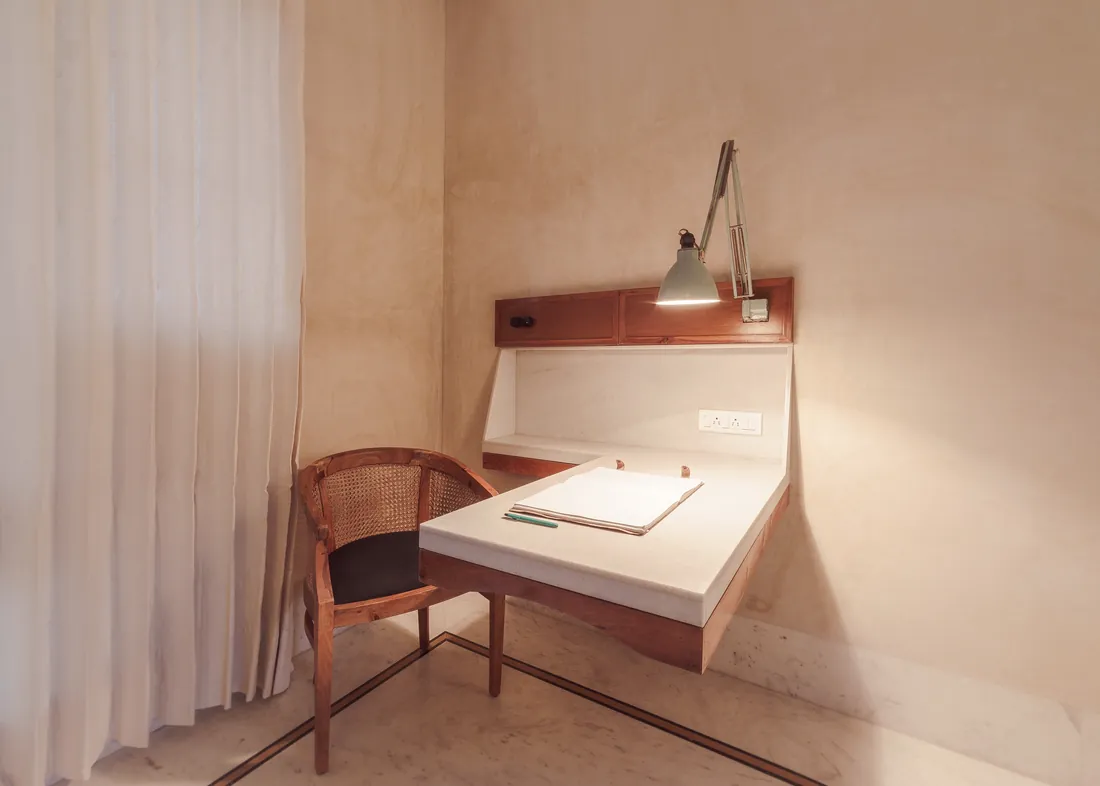 Wall-mounted desk nook — marble top, teak paneling, reading lamp